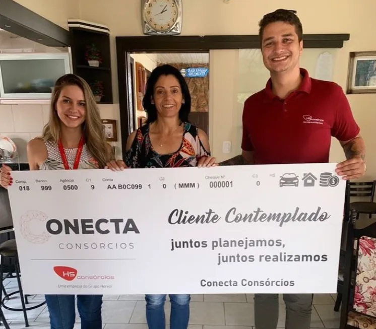 Cliente contemplada com consultores da Conecta Cons&oacute;rcios